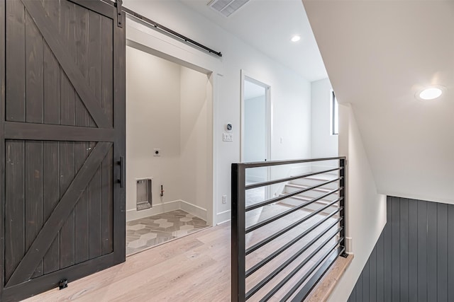interior space featuring baseboards, recessed lighting, a barn door, visible vents, and wood finished floors