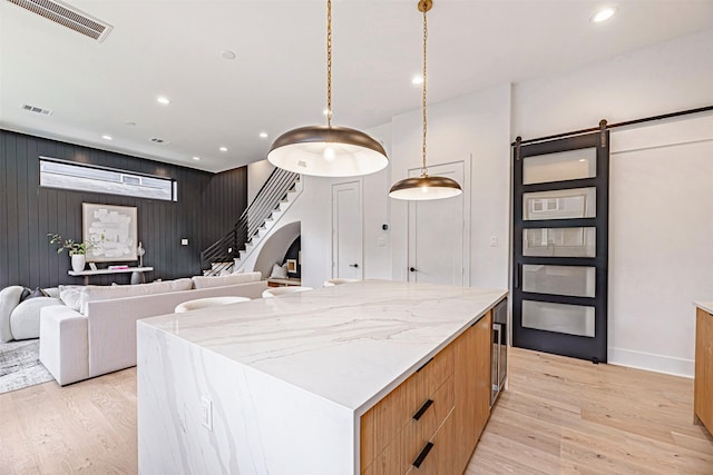 829 Alexander St, Houston, TX 77007 - kitchen with light wood finished floors, a barn door, modern cabinets, recessed lighting, and a kitchen island