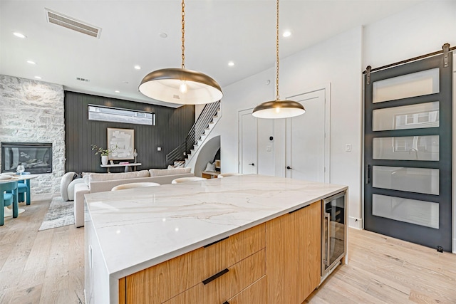 829 Alexander St, Houston, TX 77007 - kitchen with modern cabinets, light wood-style floors, light stone counters, open floor plan, and a spacious island