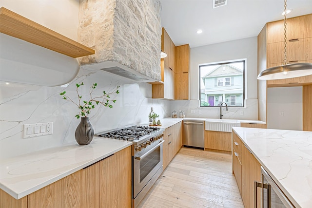829 Alexander St, Houston, TX 77007 - kitchen with modern cabinets, stainless steel appliances, a sink, and light stone countertops