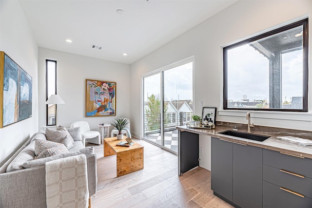 829 Alexander St, Houston, TX 77007 - kitchen with a sink, light wood finished floors, gray cabinetry, open floor plan, and modern cabinets