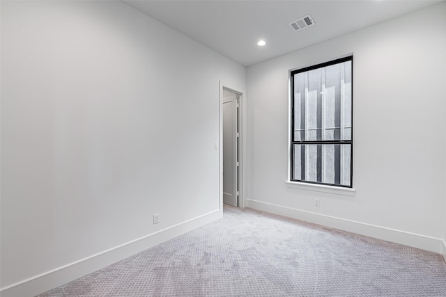 empty room featuring recessed lighting, visible vents, light colored carpet, and baseboards