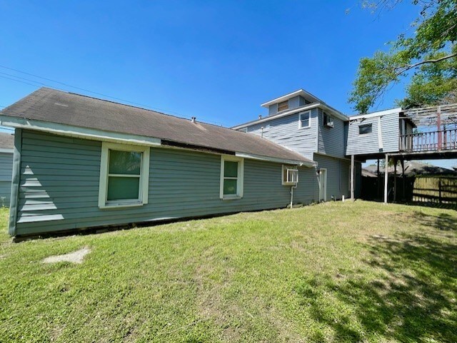 back of house with fence and a lawn