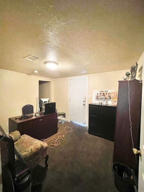 home office featuring visible vents, carpet, and a textured ceiling