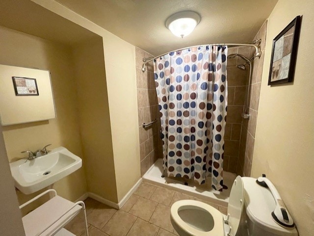 full bath featuring toilet, a shower stall, a sink, and tile patterned flooring