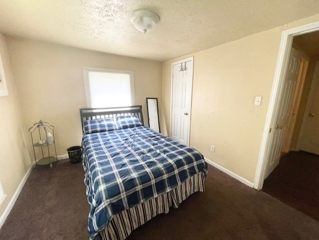 carpeted bedroom with baseboards and a textured ceiling