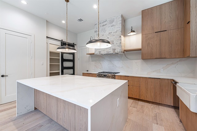kitchen with light wood-style flooring, backsplash, modern cabinets, and visible vents