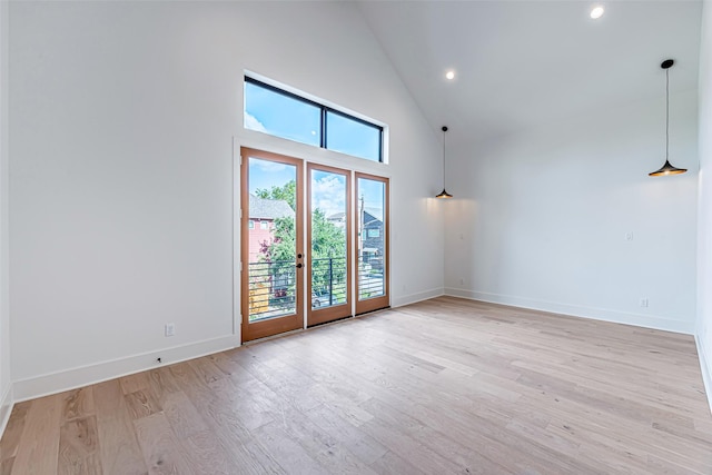 empty room featuring baseboards, high vaulted ceiling, recessed lighting, and light wood finished floors