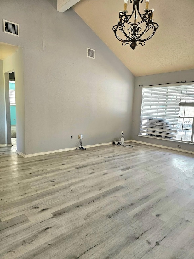 unfurnished room featuring visible vents, a wealth of natural light, and wood finished floors