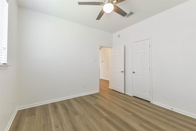 21320 Heritage Forest Ln, Porter, TX 77365 - unfurnished bedroom with wood finished floors, baseboards, and ceiling fan