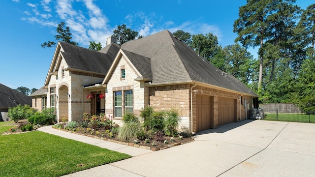 40377 Mostyn Dr, Magnolia, TX 77354 - view of front facade with roof with shingles, brick siding, concrete driveway, stone siding, and a garage