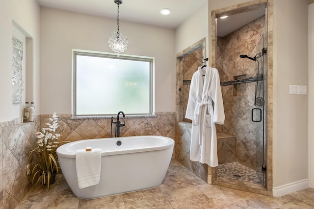 40377 Mostyn Dr, Magnolia, TX 77354 - bathroom featuring a stall shower, tile walls, a freestanding tub, and wainscoting