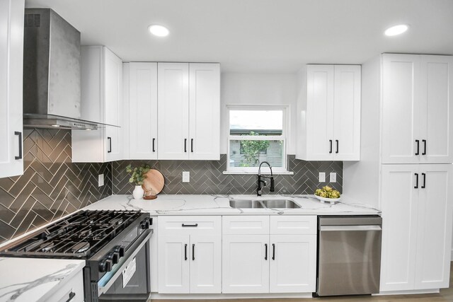 kitchen with wall chimney exhaust hood, a sink, black gas stove, light stone countertops, and stainless steel dishwasher