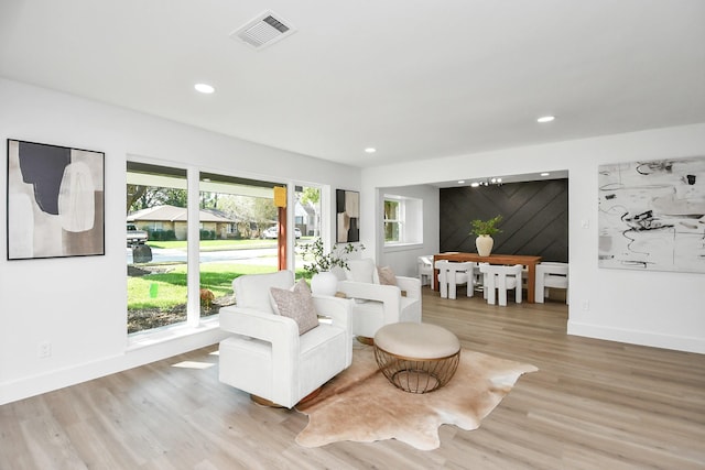 living area with visible vents, baseboards, light wood finished floors, and recessed lighting