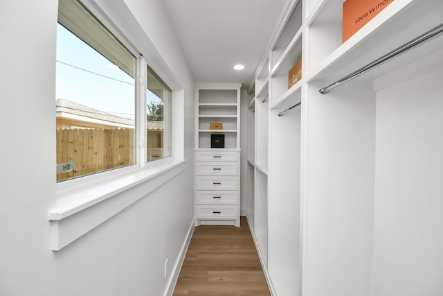 walk in closet with wood finished floors