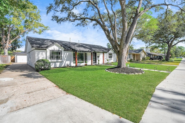 ranch-style home featuring a detached garage and a front yard