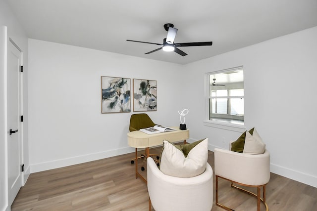 office space featuring baseboards, a ceiling fan, and wood finished floors
