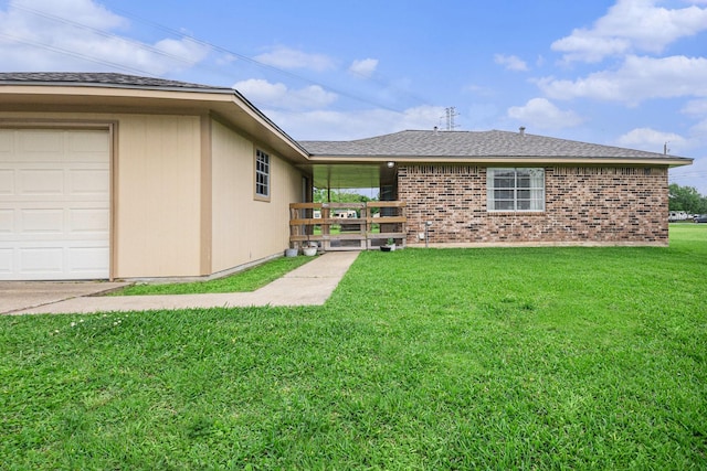 back of property featuring a lawn, brick siding, and roof with shingles