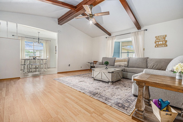living room with ceiling fan with notable chandelier, baseboards, vaulted ceiling with beams, and wood finished floors