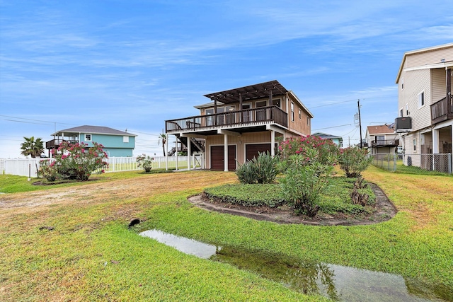 16716 Fletcher Christian Rd, Jamaica Beach, TX 77554 - view of front of property featuring a garage, driveway, a deck, a fenced backyard, and a front yard