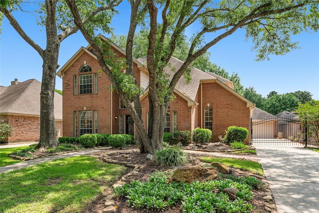 view of front of home featuring a gate, brick siding, fence, roof with shingles, and concrete driveway
