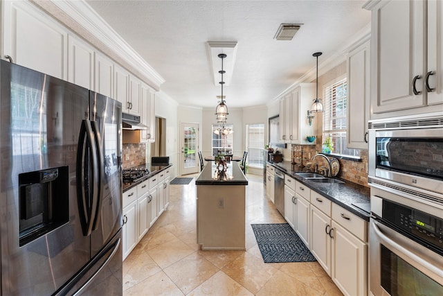 kitchen featuring tasteful backsplash, a sink, appliances with stainless steel finishes, visible vents, and under cabinet range hood