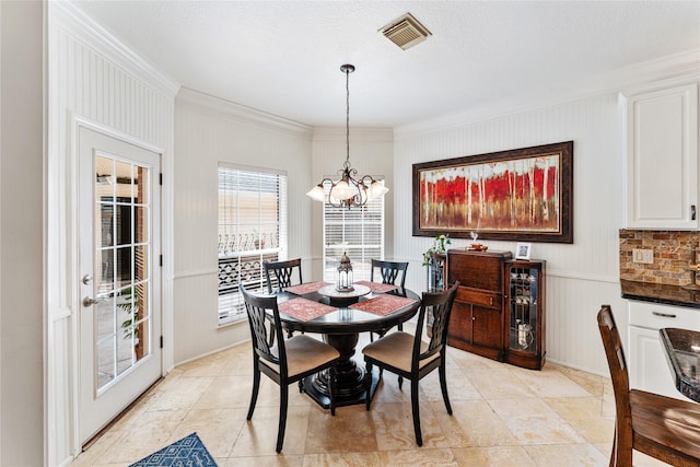 dining room featuring crown molding, a notable chandelier, and visible vents
