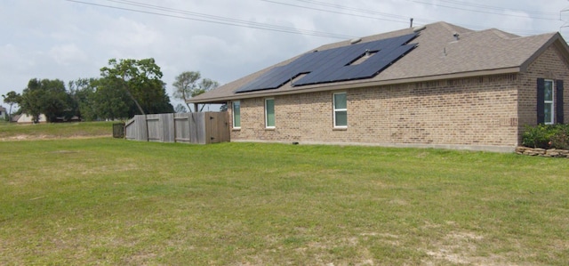 1634 William Scott St, Baytown, TX 77523 - view of side of property featuring brick siding, solar panels, a yard, and a shingled roof