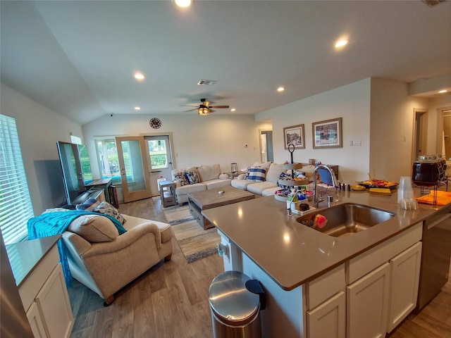 1634 William Scott St, Baytown, TX 77523 - kitchen featuring a sink, open floor plan, light wood-style floors, white cabinetry, and lofted ceiling