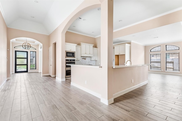 23446 Timbarra Glen Dr, New Caney, TX 77357 - foyer entrance with light wood-type flooring, ornamental molding, arched walkways, and baseboards