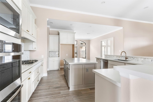 23446 Timbarra Glen Dr, New Caney, TX 77357 - kitchen featuring ornamental molding, a sink, stainless steel appliances, and a large island