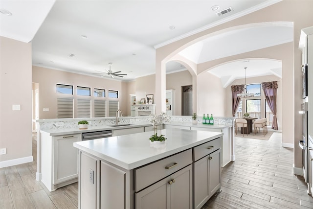 23446 Timbarra Glen Dr, New Caney, TX 77357 - kitchen featuring visible vents, a peninsula, a kitchen island, and a sink