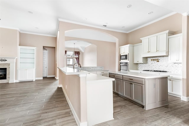 23446 Timbarra Glen Dr, New Caney, TX 77357 - kitchen featuring tasteful backsplash, light countertops, built in microwave, oven, and an island with sink