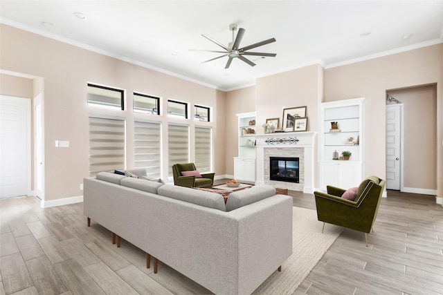 23446 Timbarra Glen Dr, New Caney, TX 77357 - living area with ceiling fan, a glass covered fireplace, light wood-style flooring, baseboards, and ornamental molding