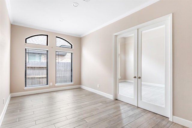 23446 Timbarra Glen Dr, New Caney, TX 77357 - spare room featuring recessed lighting, light wood-style floors, ornamental molding, baseboards, and french doors