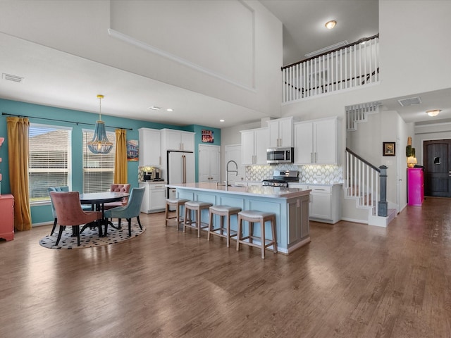 1800 Bright Way Ln, Dickinson, TX 77539 - kitchen with stainless steel appliances, a sink, a breakfast bar, a kitchen island with sink, and tasteful backsplash