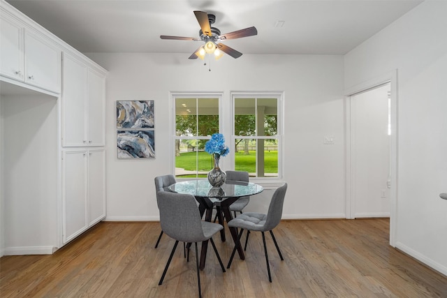 2350 Hewitt St, League City, TX 77573 - dining room with light wood-style floors, a ceiling fan, and baseboards