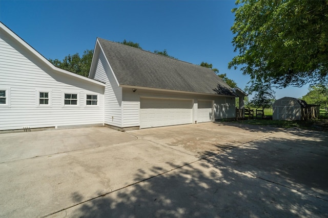 2350 Hewitt St, League City, TX 77573 - view of side of property with a shingled roof, concrete driveway, and an outdoor structure