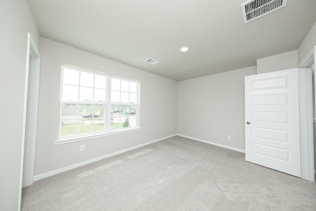 unfurnished room featuring recessed lighting, visible vents, baseboards, and light carpet