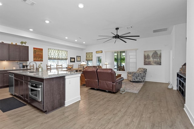 954 Golden Willow Ln, Conroe, TX 77304 - kitchen with appliances with stainless steel finishes, light wood-type flooring, dark brown cabinetry, recessed lighting, and healthy amount of natural light