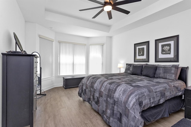 954 Golden Willow Ln, Conroe, TX 77304 - bedroom with a tray ceiling, wood finished floors, baseboards, and a ceiling fan