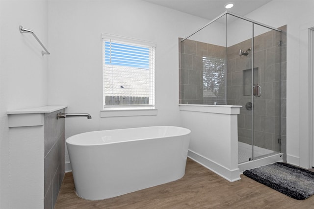 954 Golden Willow Ln, Conroe, TX 77304 - full bathroom with wood finished floors, a soaking tub, a shower stall, and baseboards