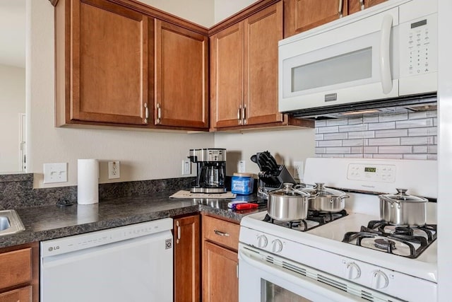4210 Church St, Galveston, TX 77550 - kitchen with backsplash, brown cabinetry, dark countertops, and white appliances