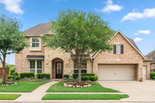 11710 Saporito Way, Richmond, TX 77406 - traditional-style house with a shingled roof, stone siding, concrete driveway, brick siding, and a front lawn