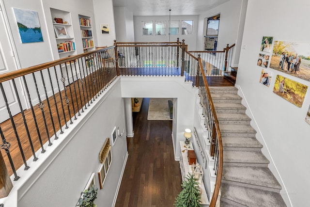 11710 Saporito Way, Richmond, TX 77406 - stairs featuring built in shelves, wood finished floors, and baseboards