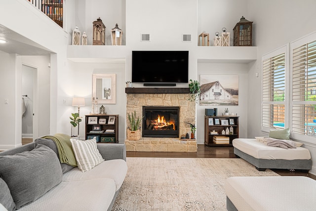 11710 Saporito Way, Richmond, TX 77406 - living room featuring visible vents, a stone fireplace, a high ceiling, and wood finished floors