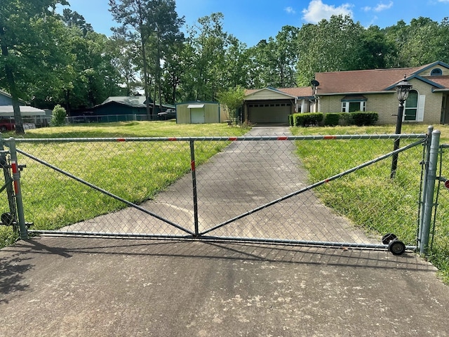 408 Redbud Rdg, Onalaska, TX 77360 - view of front facade with a gate, fence, aphalt driveway, and a front yard