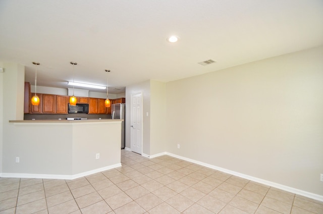 9518 Prairie Dale Ct, Houston, TX 77075 - kitchen featuring black microwave, brown cabinetry, a peninsula, light countertops, and baseboards