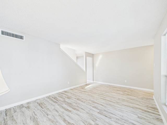 below grade area featuring visible vents, baseboards, and wood finished floors