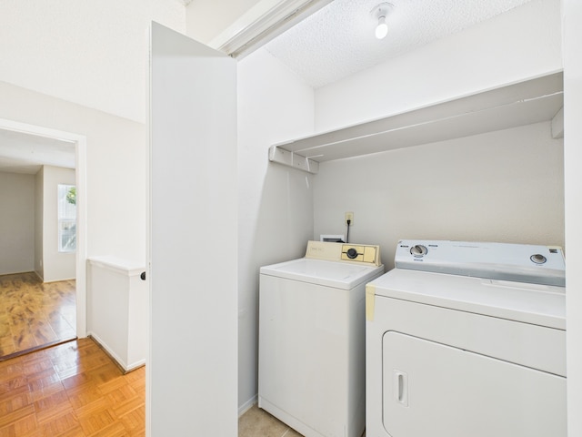 laundry area with laundry area, washing machine and dryer, and a textured ceiling